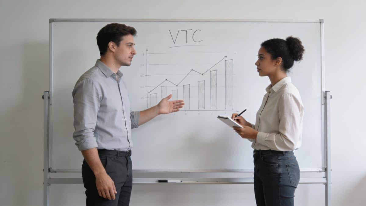 Candidat VTC et formateur devant tableau avec graphiques