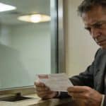 commercant inquiet examinant cheque refuse devant guichet banque