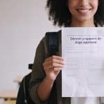 etudiante souriante tenant un rapport de stage approuve