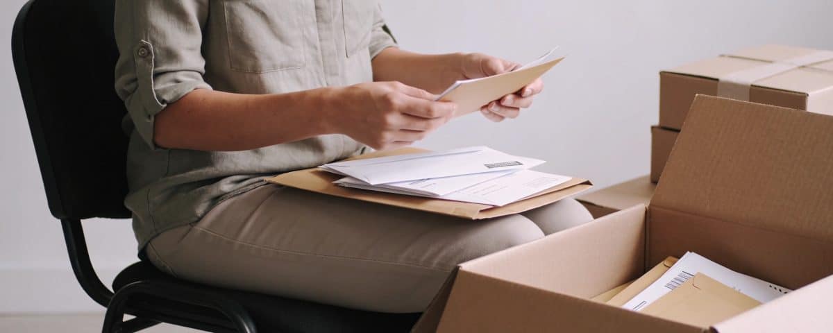 Femme assise triant enveloppes et boites carton