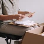 Femme assise triant enveloppes et boites carton