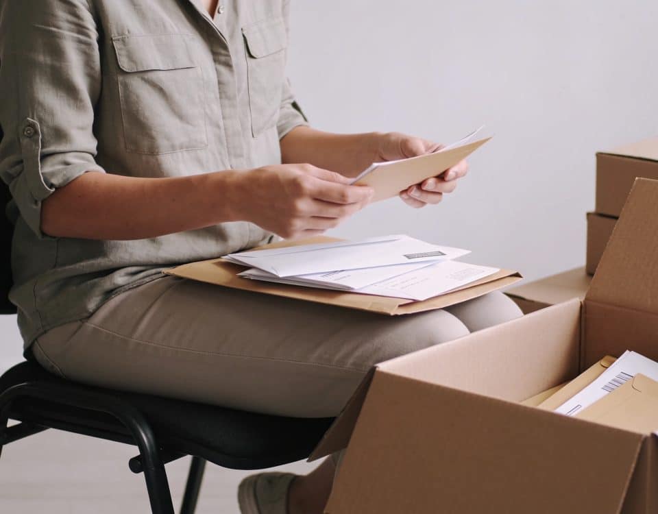 Femme assise triant enveloppes et boites carton