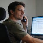 Homme assis devant ordinateur consultant details d appel