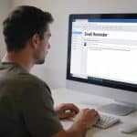 homme assis devant ordinateur envoyant email de rappel