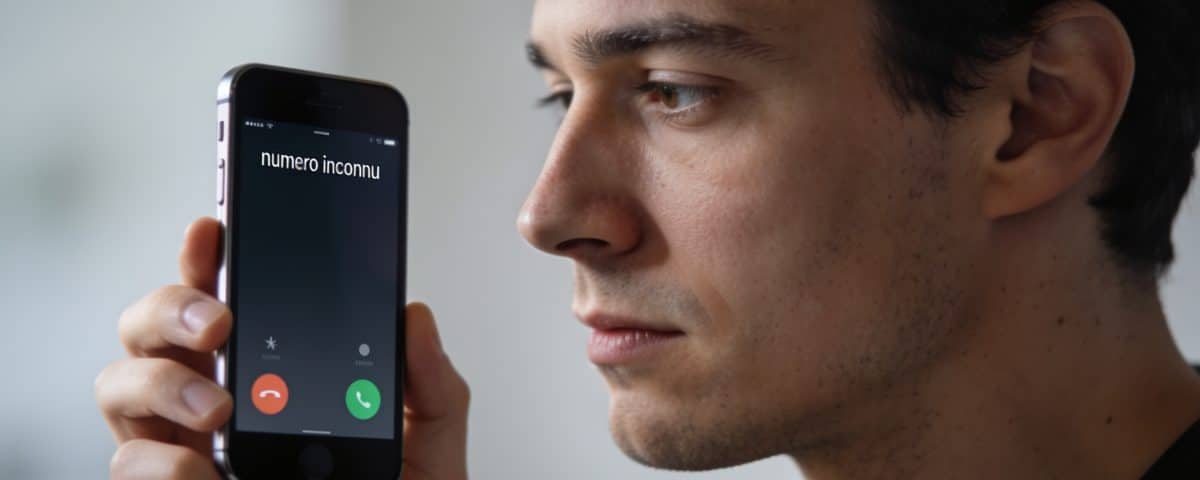 Homme regarde smartphone affiche numero inconnu en gros plan