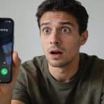 Homme surpris regardant ecran smartphone montrant appel inconnu