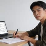 Jeune entrepreneur signe documents societaires sur ordinateur