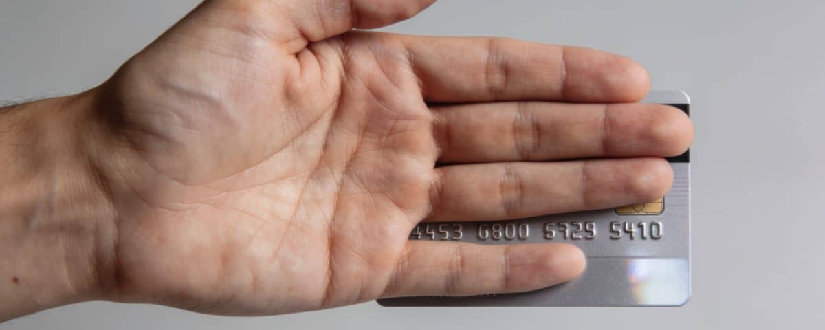 Main de profil cachant les chiffres dune carte bancaire