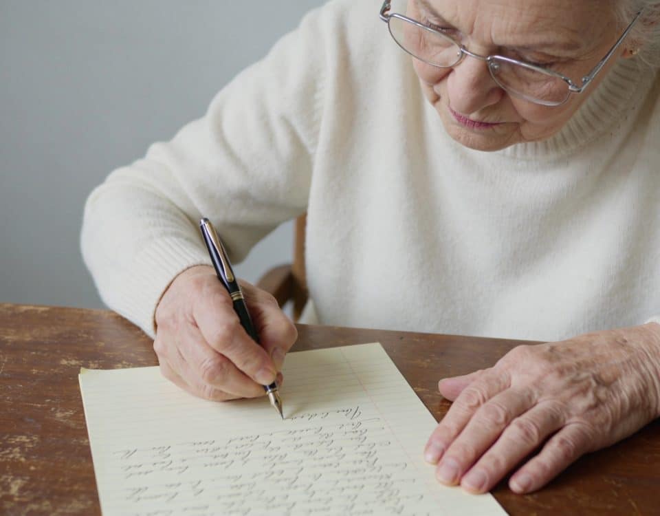 Main vieillissante ecrivant un document juridique manuscrit