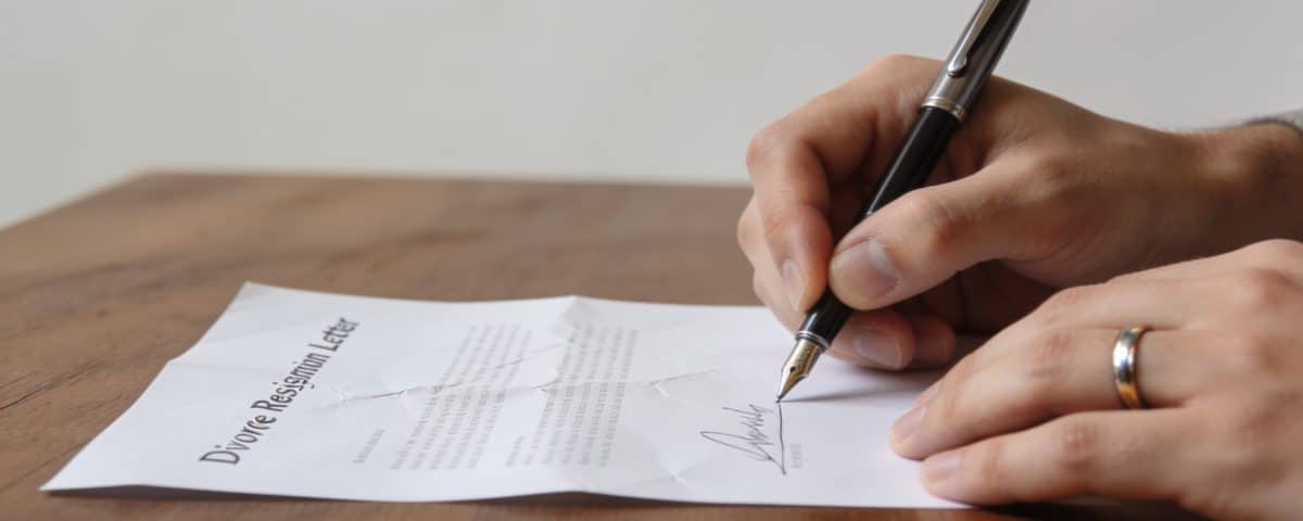 Mains signant une lettre de renonciation divorce