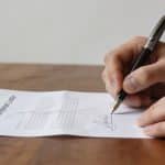 Mains signant une lettre de renonciation divorce