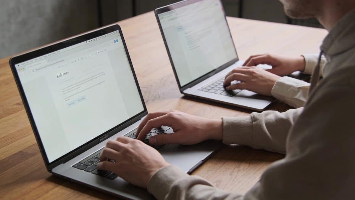 Deux personnes ecrivent un email sur ordinateur