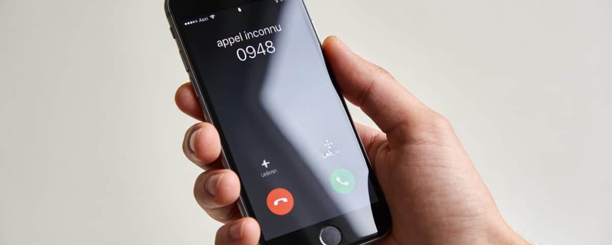 Smartphone en main affichant appel inconnu 0948