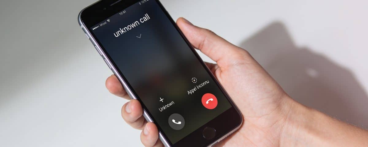 Smartphone en main affichant un appel inconnu