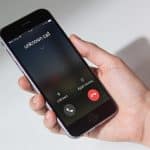 Smartphone en main affichant un appel inconnu