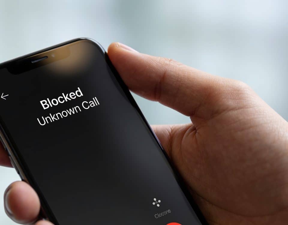 Smartphone en main affichant un appel inconnu bloqué