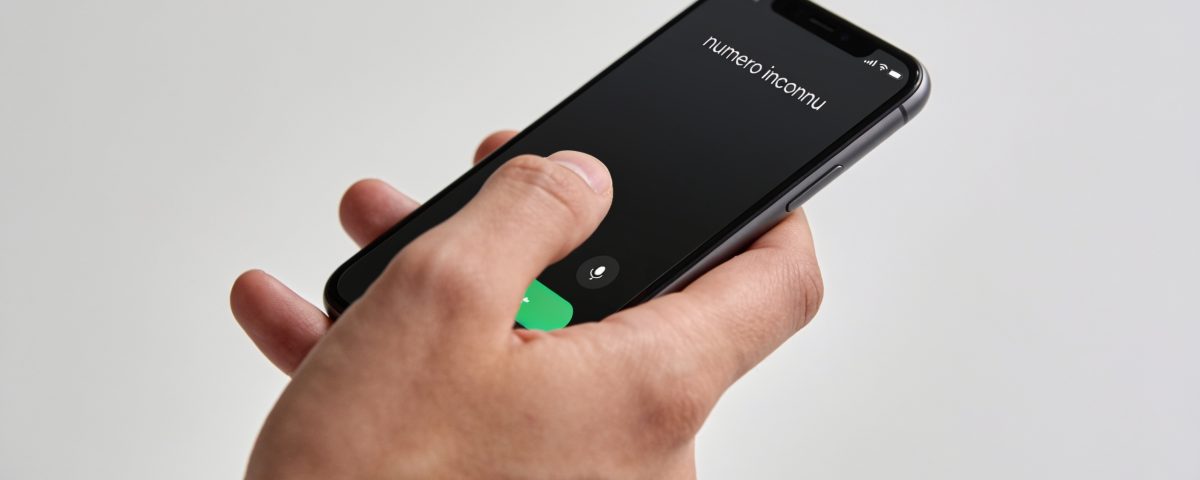Smartphone en main affichant un numero inconnu