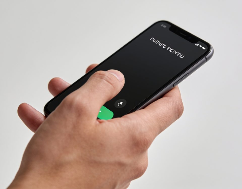 Smartphone en main affichant un numero inconnu
