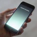 smartphone en main affichant numero inconnu ecran lumineux