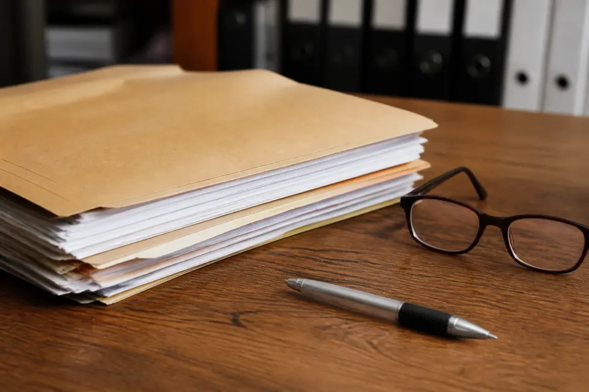 Bureau avec dossier papier, stylo et lunettes posees