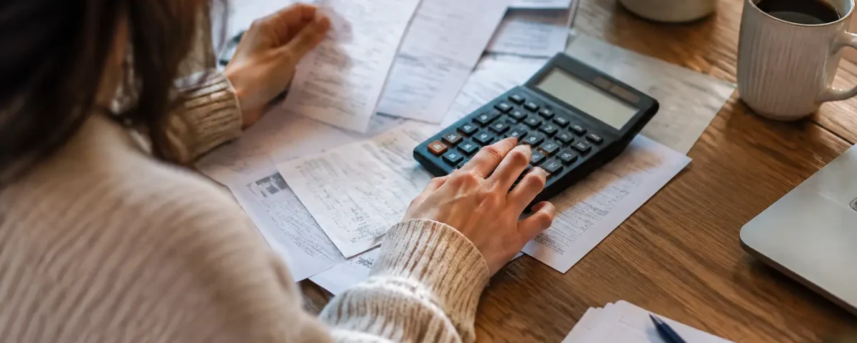 Calculatrice et factures posees sur une table en bois