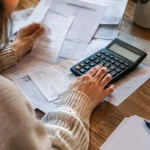 Calculatrice et factures posees sur une table en bois