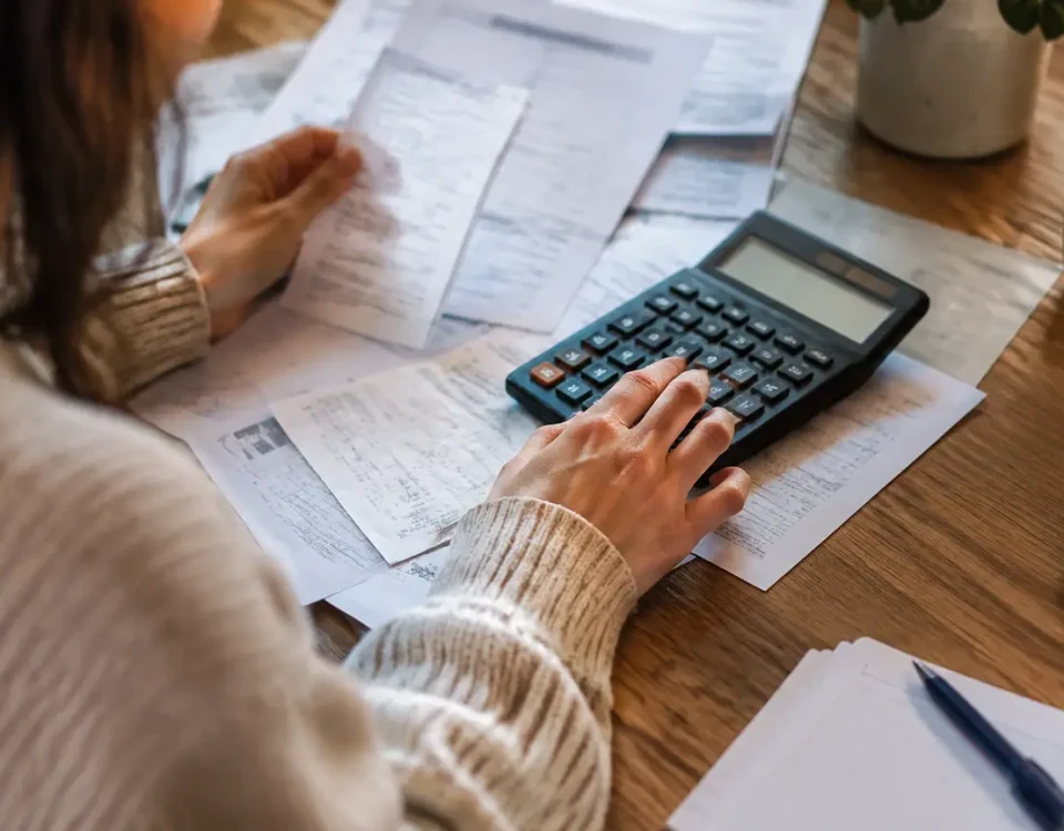 Calculatrice et factures posees sur une table en bois