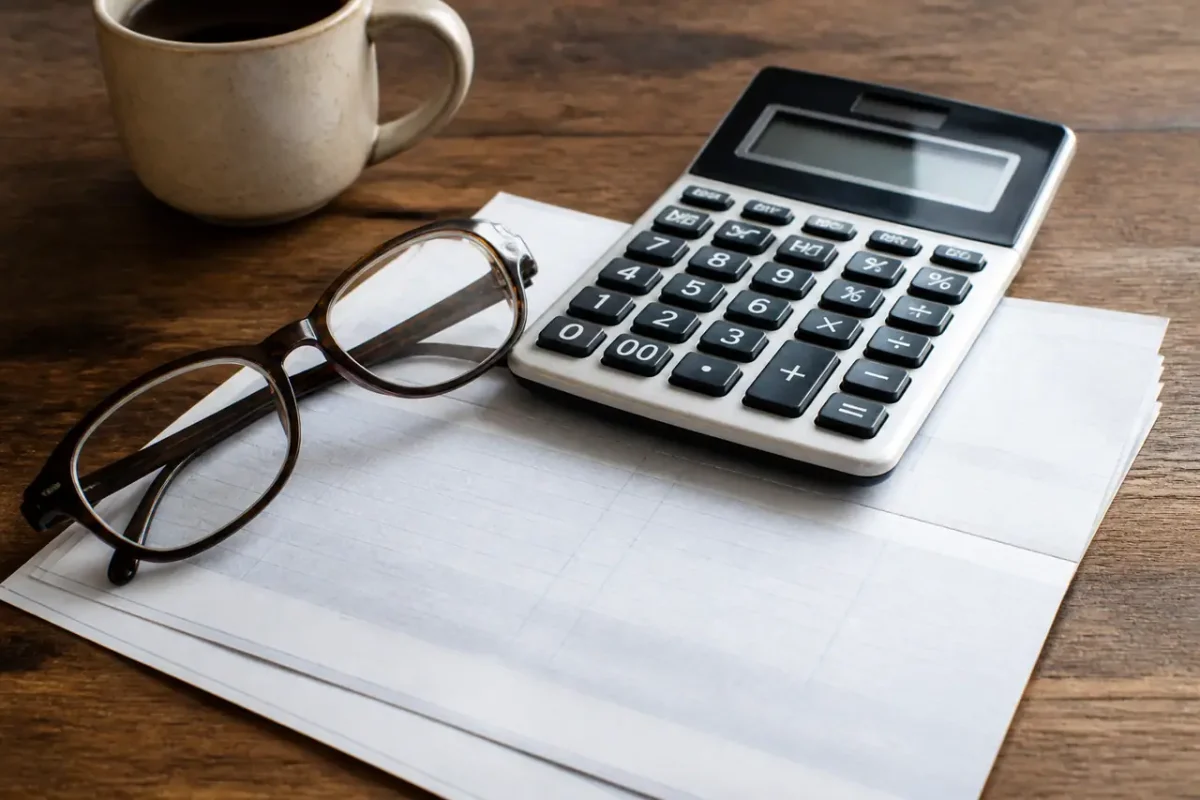 Calculatrice et lunettes posees sur un releve bancaire