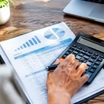 Une calculatrice posee sur un rapport budgetaire ouvert