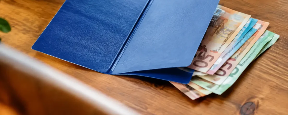 Carnet bleu ouvert sur une pile de billets