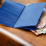 Carnet bleu ouvert sur une pile de billets