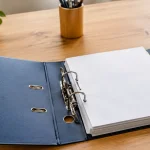 Un classeur ouvert sur un bureau en bois clair