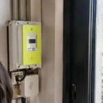 Compteur electrique pose debout pres d une fenetre sombre
