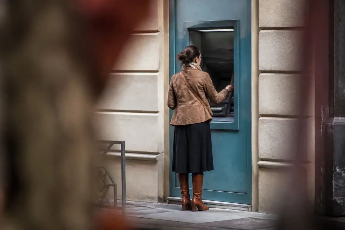 Distributeur automatique de billets dans une rue avec client
