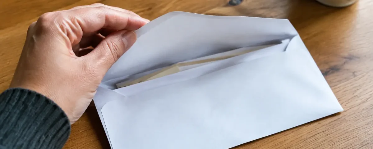 Enveloppe ouverte posee sur une table en bois