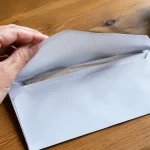 Enveloppe ouverte posee sur une table en bois