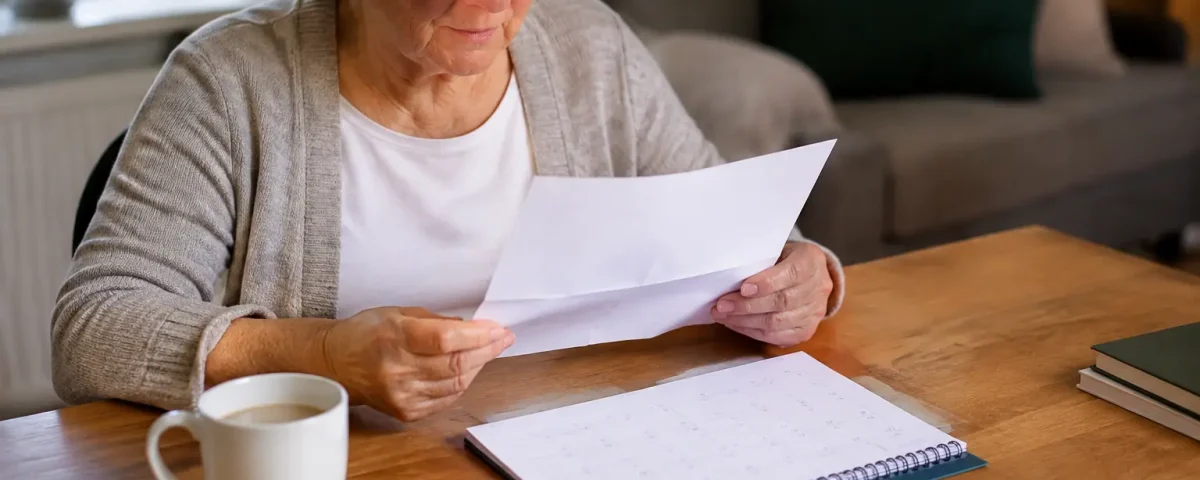 Femme agee assise lisant une lettre pres du calendrier