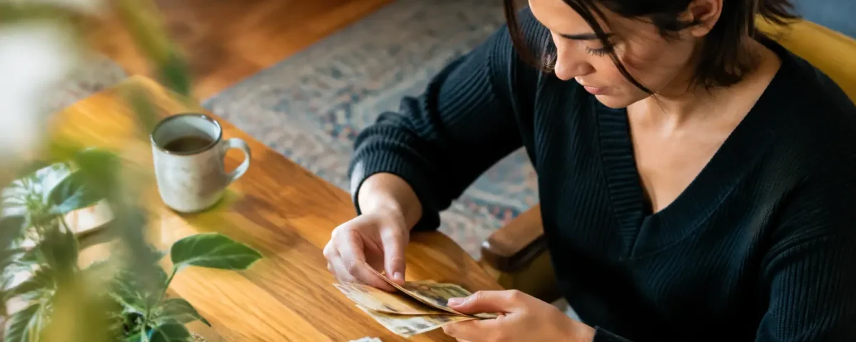 Femme assise comptant des billets sur table en bois