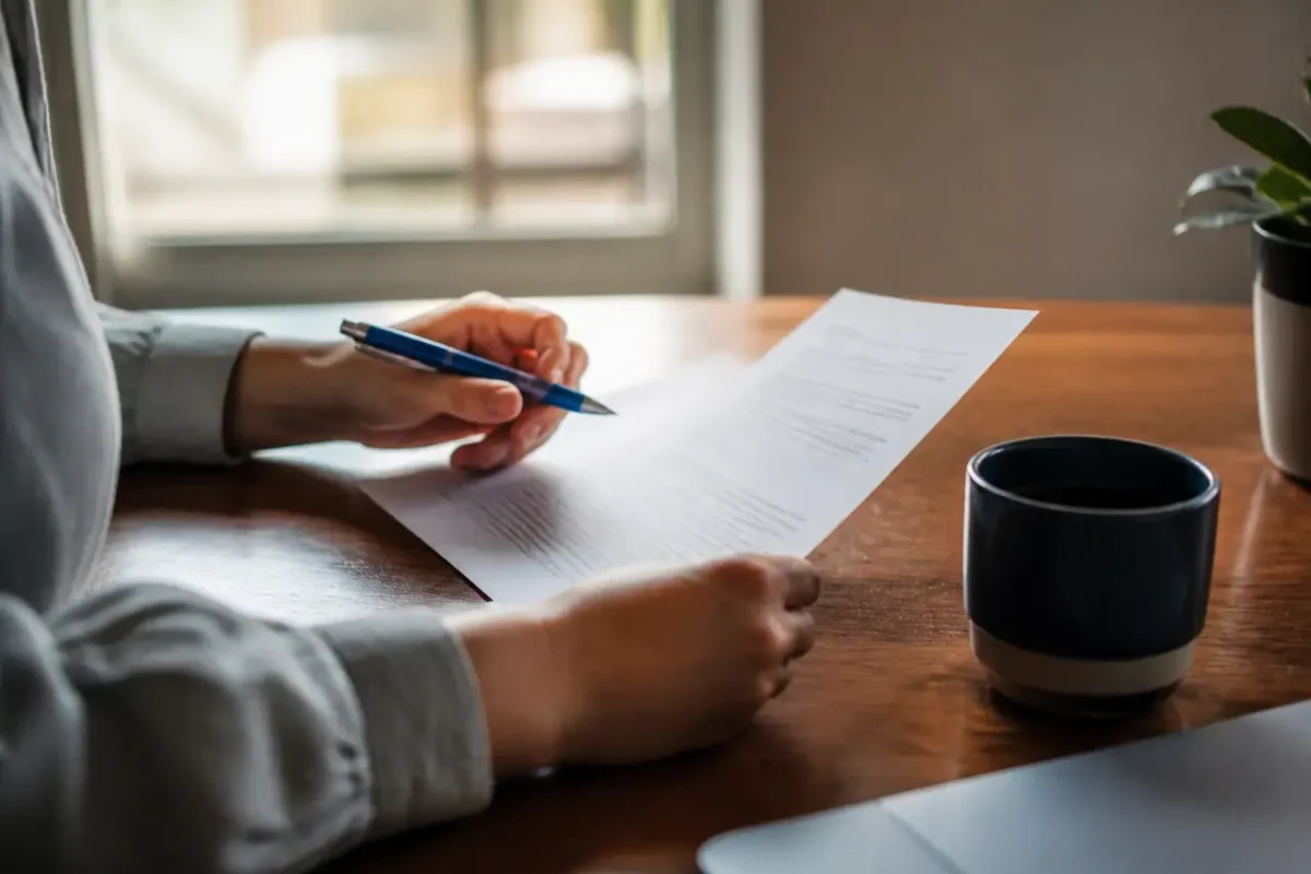 Lettre imprimee sur bureau, stylo bleu et tasse