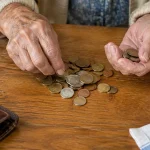 Mains agees penchees comptant des pieces sur une table