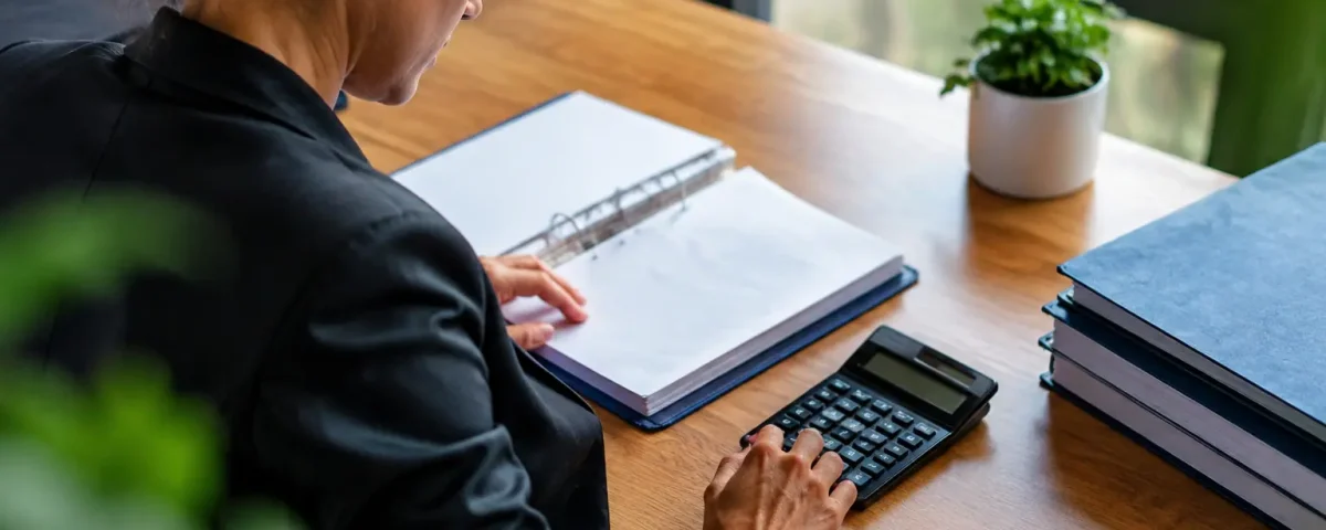 Professionnel assis devant un bureau avec calculatrice et classeur