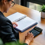 Professionnel assis devant un bureau avec calculatrice et classeur