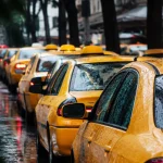 Rangee de taxis jaunes immobilises sous la pluie battante