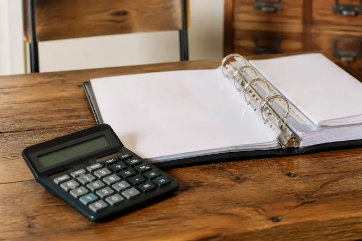 Table en bois avec calculatrice et classeur ouvert
