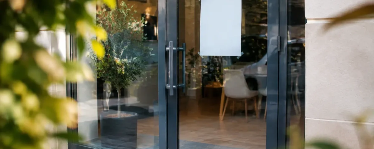 Vitrine agence fermee avec affiche collee sur la porte