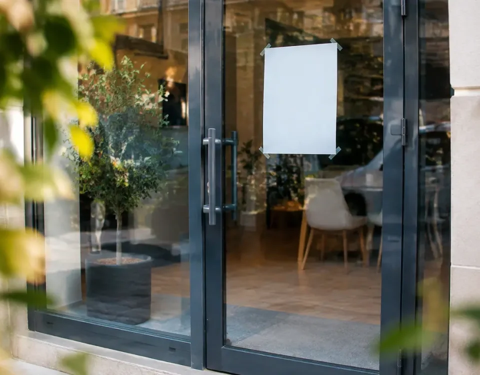 Vitrine agence fermee avec affiche collee sur la porte
